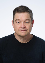 Portrait of a middle-aged man with a neutral expression wearing a black shirt.