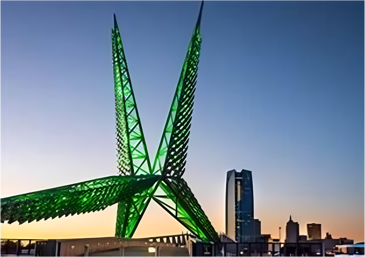 A large green illuminated star-shaped sculpture at sunset in an urban setting.